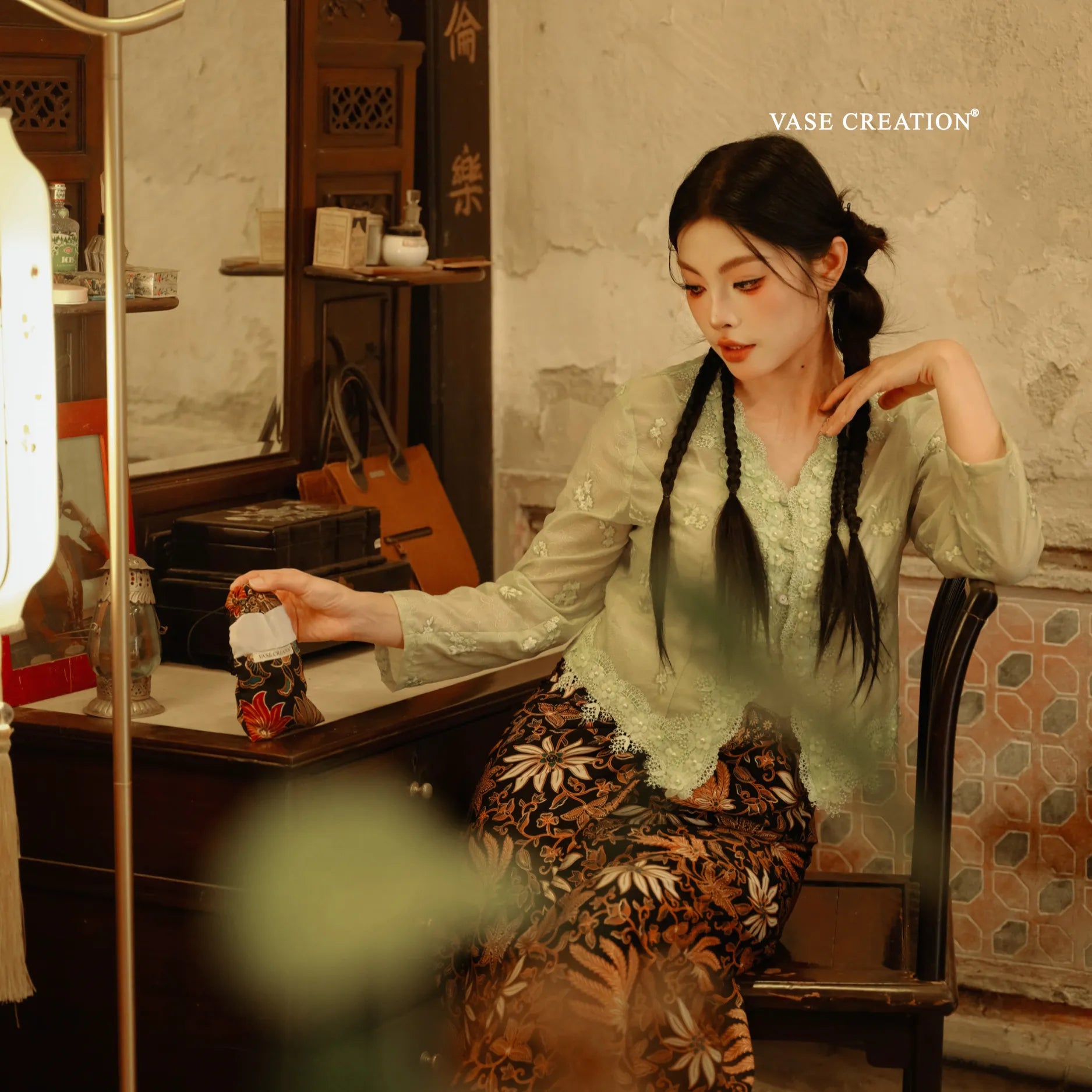 A peranakan nyonya lady holding Vase Creation Heritage Batik Journey Set